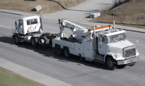 A heavy-duty tow truck safely recovering a large vehicle on the road with reliability and care.